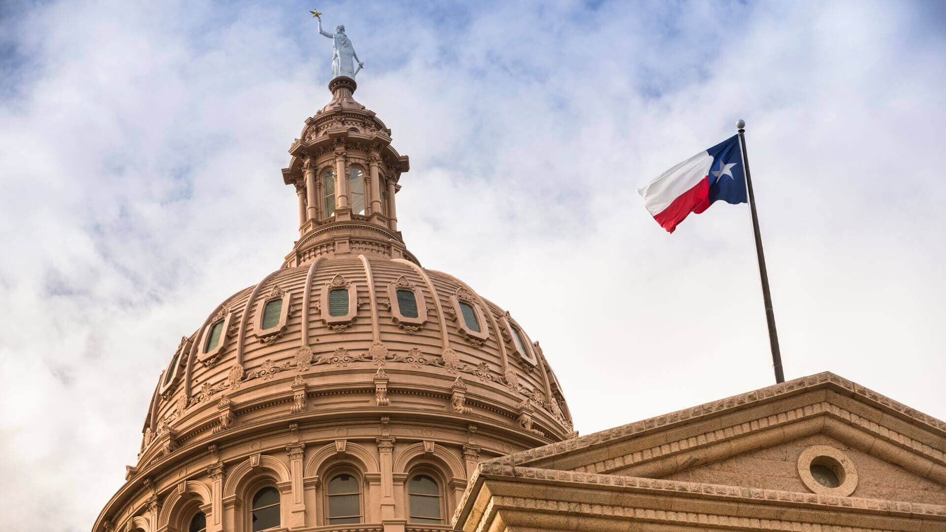 The Texas State Capitol dome with the Texas flag flying.