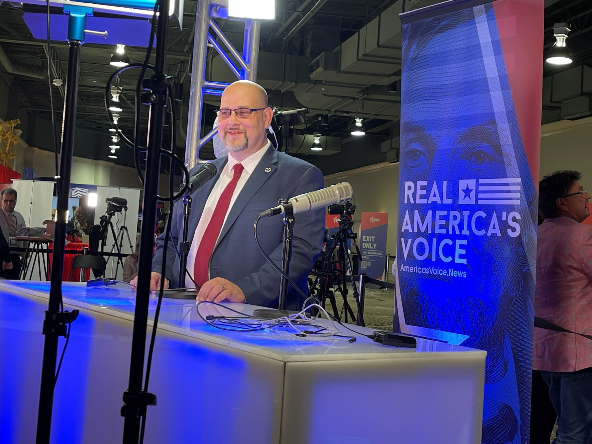 Daniel Miller being interviewed on a news set under broadcast lights.